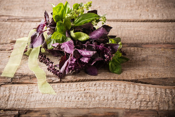 bunch of purple and green basil on a wooden background