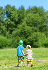 Obraz premium Little boy and girl hand in hand