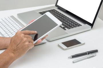 Man hands holding tablet  with laptop computer background