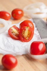 Red small tomatoes on wood board.