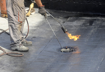 Roofer preparing part of bitumen roofing