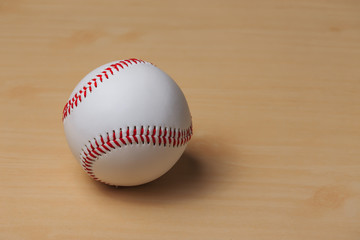 A baseball on a new wood table