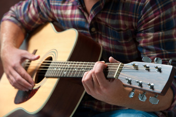 musician playing acoustic guitar