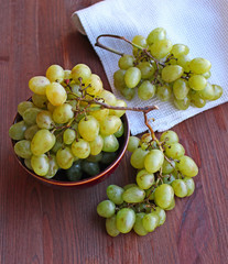 Fresh white grapes in ceramic plate on the wooden table