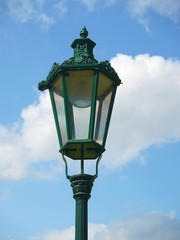 Old green metal lantern against blue sky
