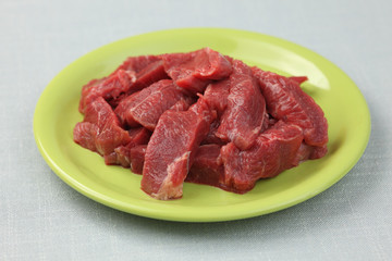 Raw fillet beef steaks on a green plate