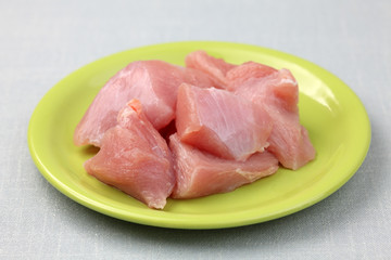 Raw turkey fillet on a green plate