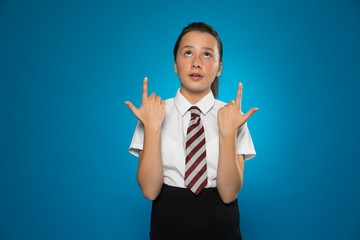 Attractive schoolgirl pointing above her head