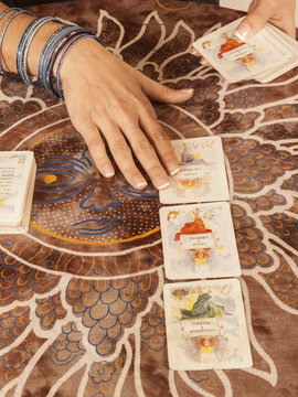 Manos de mujer con Cartas de Tarot. Vista superior