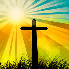 cross in a grass with sunset sky background