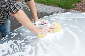 Man cleaning car's bonnet