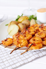 Prawns dish with potatoes and sauce with glass