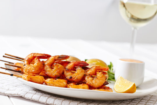 Prawns dish with potatoes and sauce with glass of wine