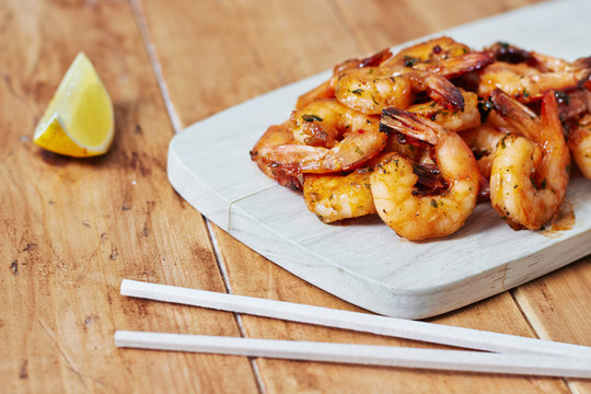 Shrimps on a wooden board with chopsticks