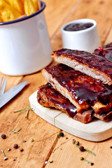 Barbecue ribs on vintage wooden table and sauce