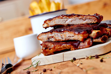 Barbecue ribs on vintage wooden table with french fries - obrazy, fototapety, plakaty