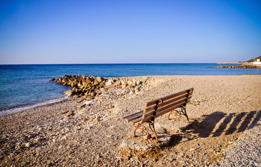 Fototapeta na wymiar Bench by the water. Aegean sea, Greece