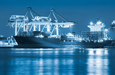 Gantry crane loading and unloading cargo container  from cargo ship at port to show global...
