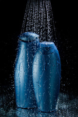 shampoo and gel bottles in falling drops of water - 69396073