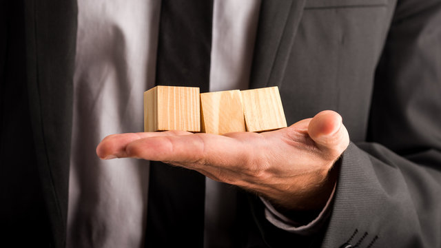 Businessman holding three blank wooden cubes