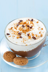 chocolate dessert with cream and amaretti in cup on blue table