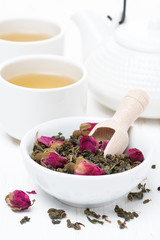 Obraz na płótnie Canvas green tea with rosebuds, cups and teapot, vertical