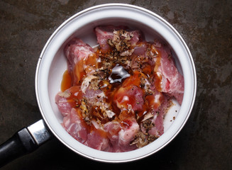 Raw pork meat with garlic pepper and shell sauce in pot before c