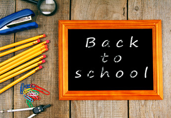 Frame and school tools. Vertically. Wooden background.
