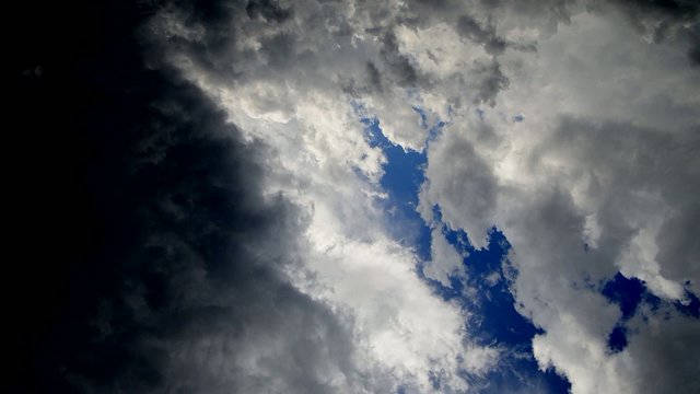 Moving clouds and birds on blue sky.