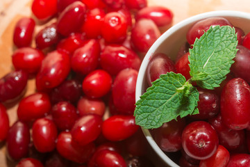fresh cornel berries in white cup and wooden table