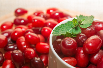 cornel berries in a white cup on a wooden board