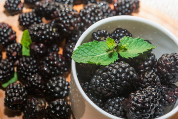 berries with mint  in white  cup on a wooden table.
