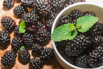 Blackberries in cup on a wooden table.