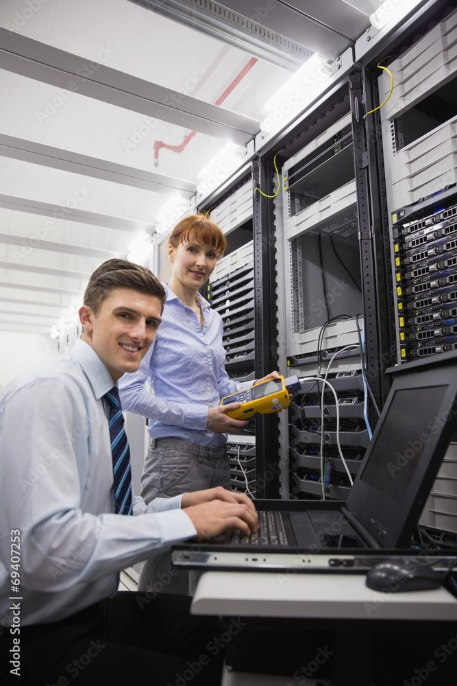 Aufkleber team of technicians using digital cable analyser on servers