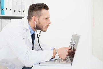 Obraz na płótnie Canvas Technician listening to laptop with stethoscope