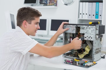 Young technician working on broken computer