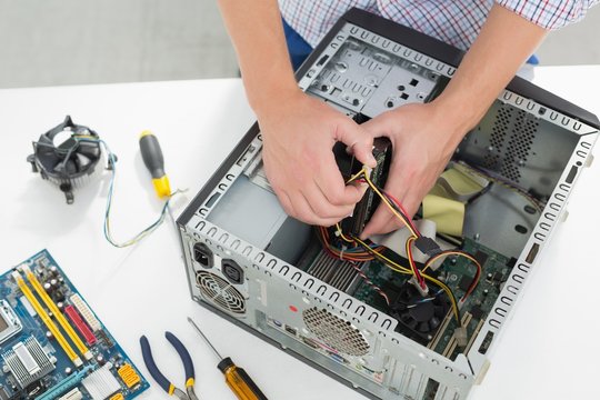 Young technician working on broken computer
