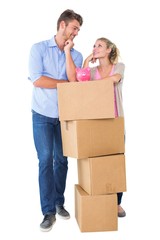 Fototapeta na wymiar Attractive young couple leaning on boxes with piggy bank