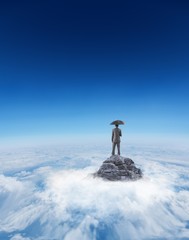 Composite image of businessman standing under umbrella