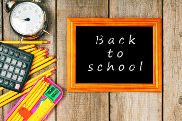 Frame and school tools. Vertically. Wooden background.