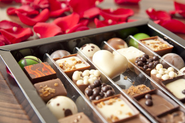 Box of tasty chocolates among rose petals - a romantic valentine