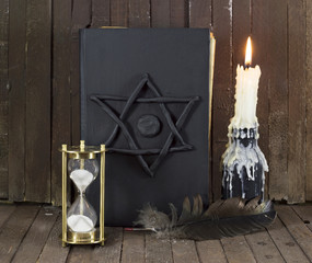 Black magic book with candle and quill