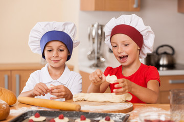 little children making cakes and talking.