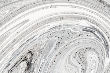 Mix of a white and black paint, closeup.