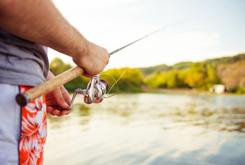 fishman with rod at river bank