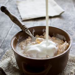 Bowl of cornflakes on wooden table.