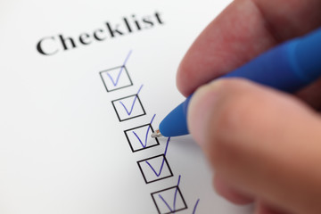 Hand filling a checklist