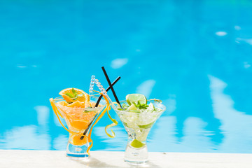 Orange and lime Mojito by the swimming pool