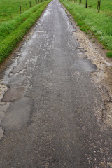 Regennasse marode Landstraße mit starken Frostschäden