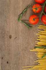 spaghetti with tomatoes basil on wood background